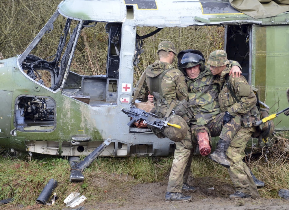 British soldiers help a simulated casualty from a crashed helicopter Canvas Art - Andrew ChittockStocktrek Images (17 x 12)