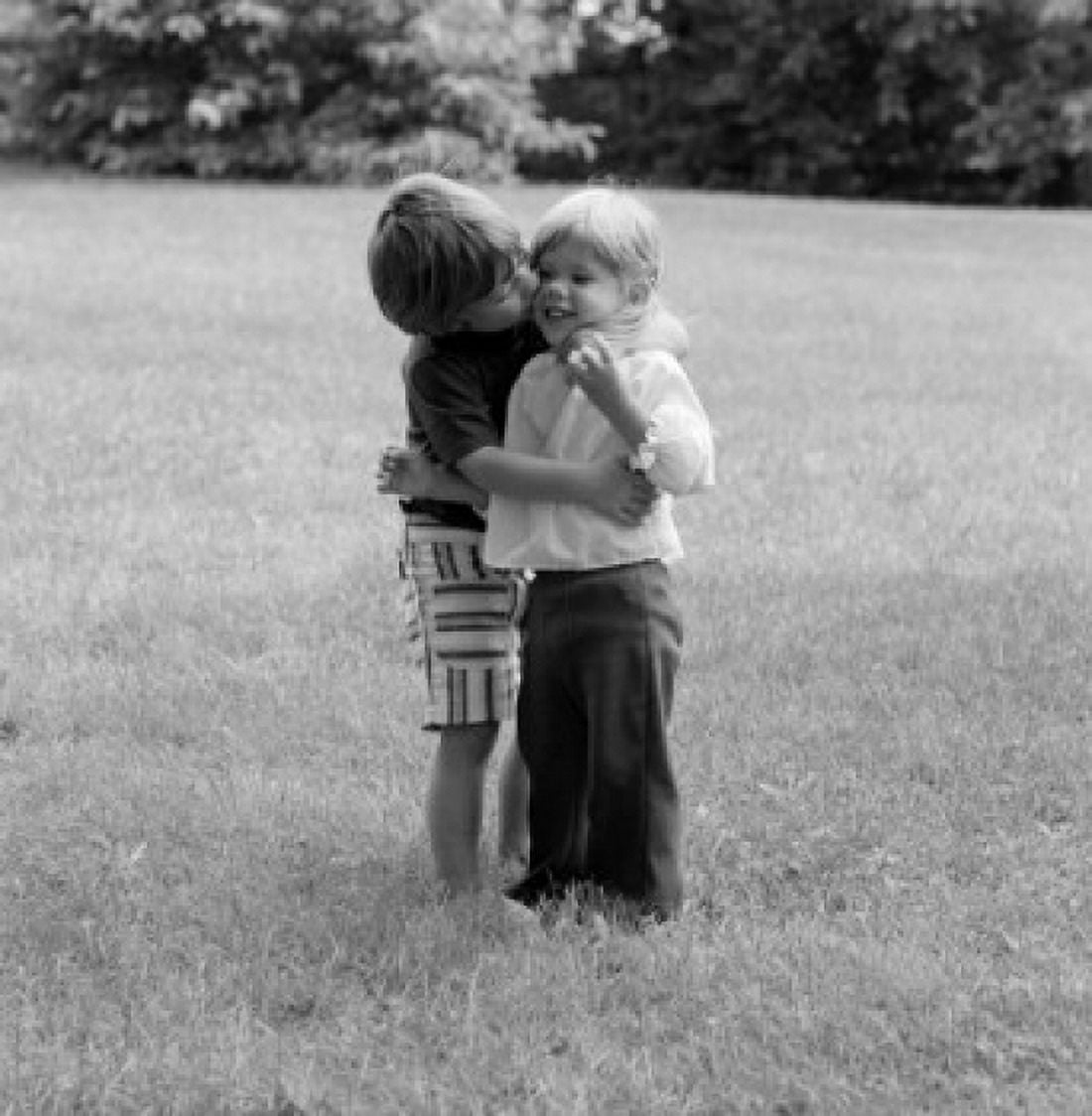 Brother kissing sister in park Canvas Art - (24 x 36)