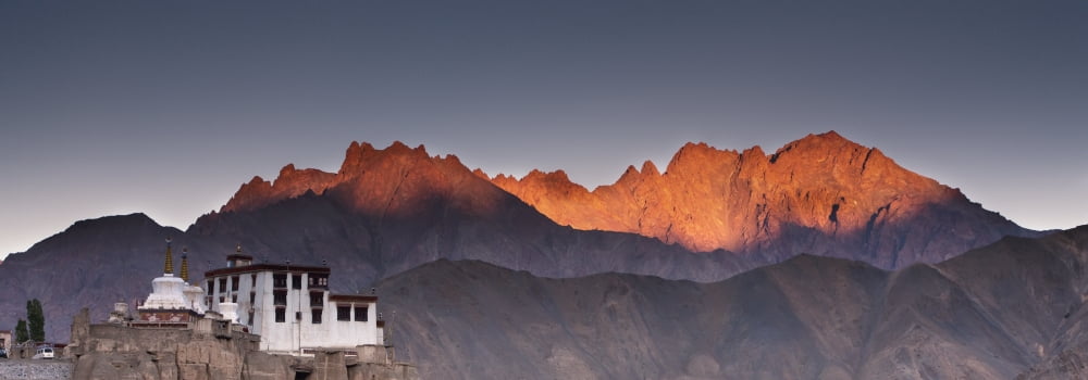 A Building On A Rock Ledge With Alpenglow Over The Mountains In The Background Lamayuru Ladakh India Canvas Art - David DuChemin Design Pics (36 x 14)