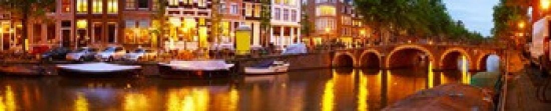 Buildings along a canal at dusk Amsterdam Netherlands Canvas Art - Panoramic Images (24 x 5)
