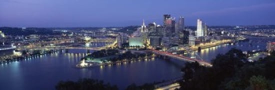 Buildings along a river lit up at dusk Monongahela River Pittsburgh Allegheny County Pennsylvania USA Canvas Art - Panoramic Images (36 x 12)