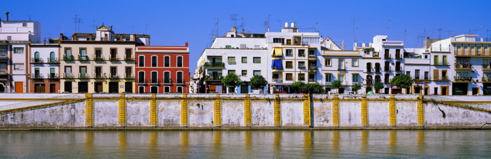 Buildings at the riverside Guadalquivir River Seville Seville Province Andalusia Spain Canvas Art - Panoramic Images (6 x 18)