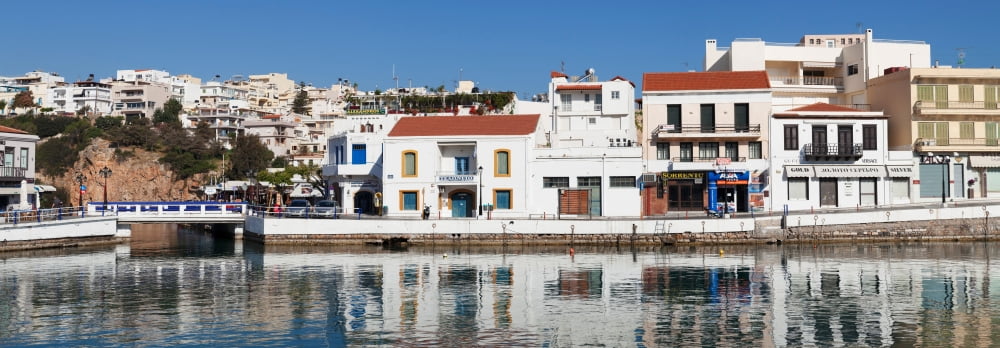Buildings at waterfront Agios Nikolaos Lasithi Crete Greece Canvas Art - Panoramic Images (12 x 36)