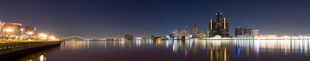 Buildings in a city lit up at dusk Detroit River Detroit Michigan USA Canvas Art - Panoramic Images (36 x 12)