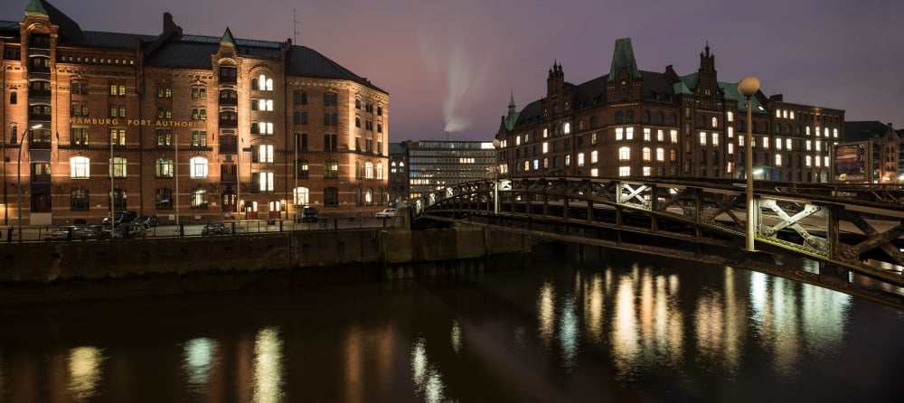 Buildings lit up at the waterfront during night HafenCity Hamburg-Mitte Hamburg Germany Canvas Art - Panoramic Images (7 x 15)