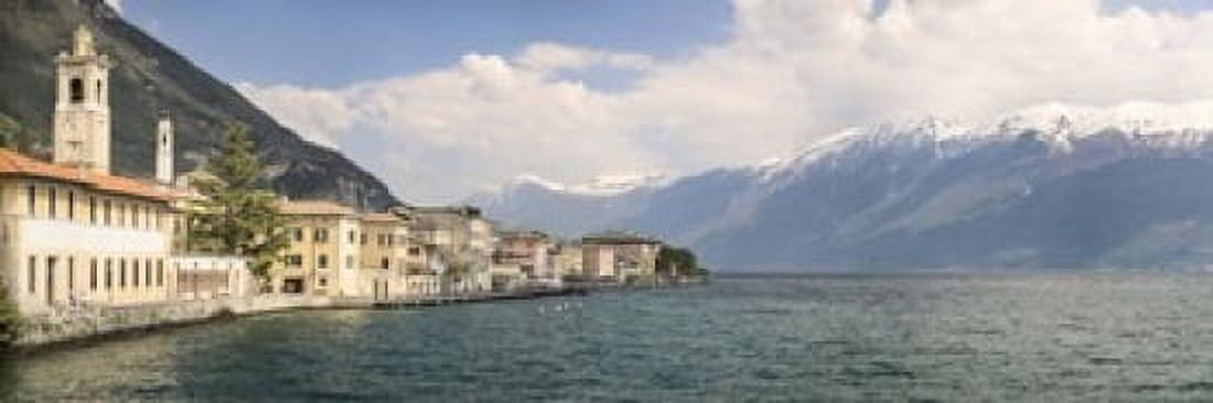 Buildings at the waterfront with snowcapped mountain in the background Gargnano Monte Baldo Lake Garda Lombardy Italy Canvas Art - Panoramic Images (18 x 6)