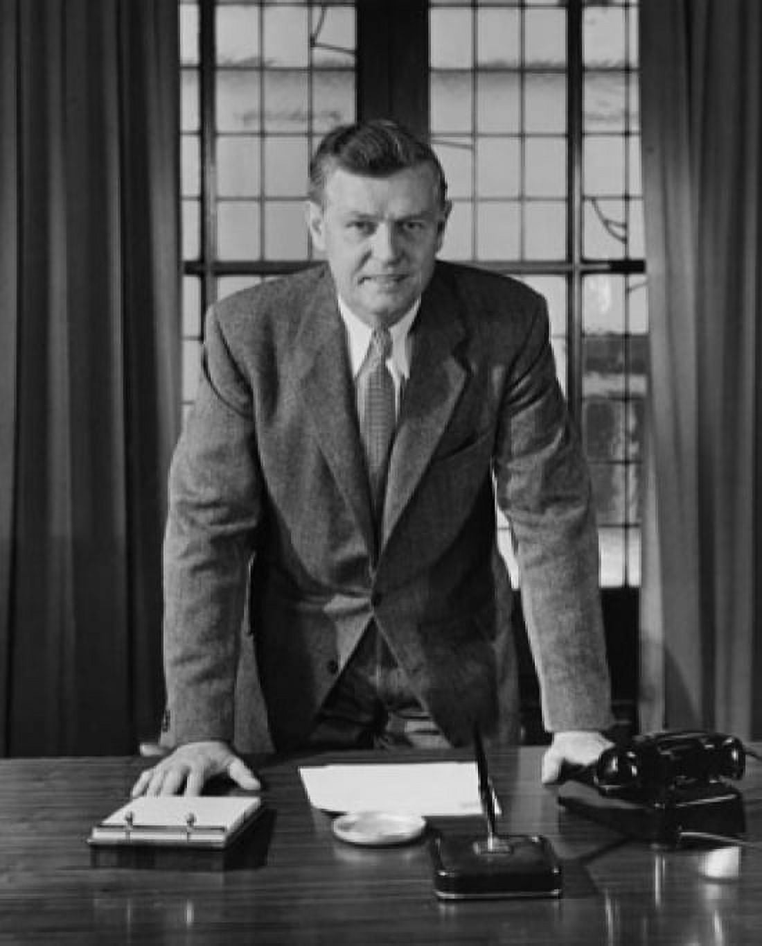 Businessman leaning against a desk in an office Canvas Art - (24 x 36)