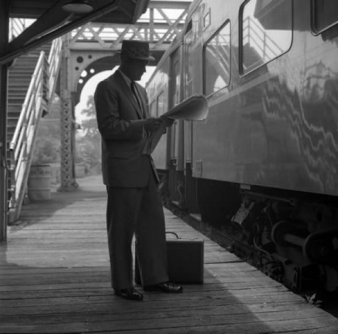 Businessman reading newspaper on railroad platform Canvas Art - (18 x 24)
