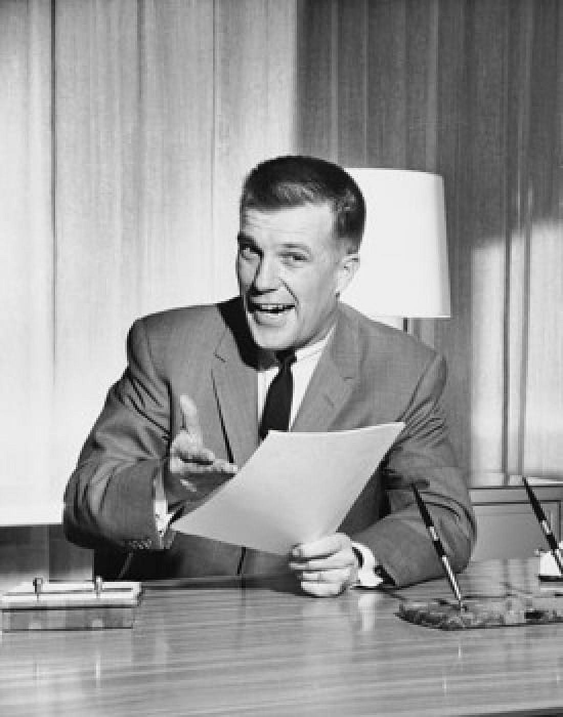 Businessman sitting at a desk and holding documents in an office Canvas Art - (24 x 36)