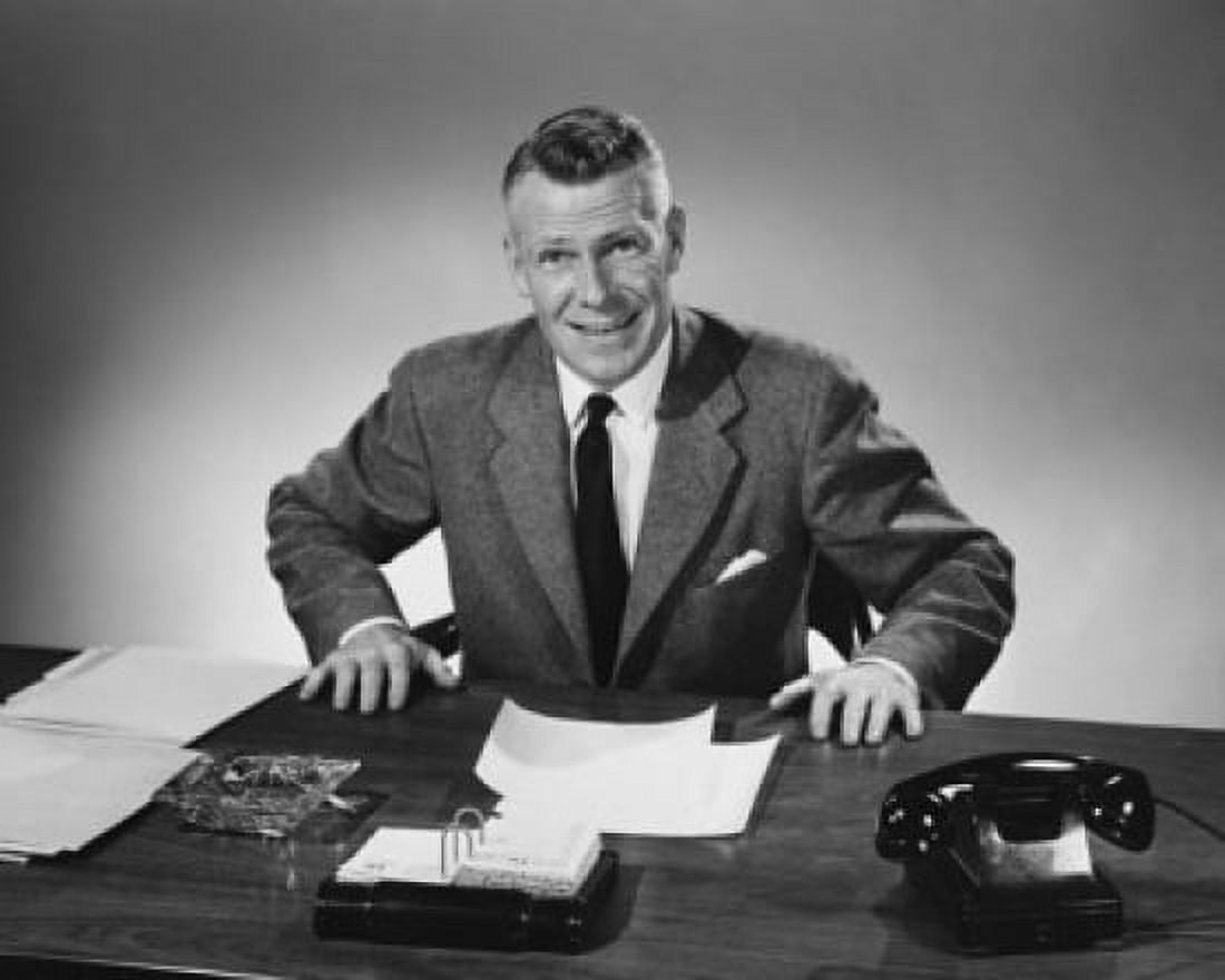 Businessman sitting at a desk and smiling in an office Canvas Art - (24 x 36)