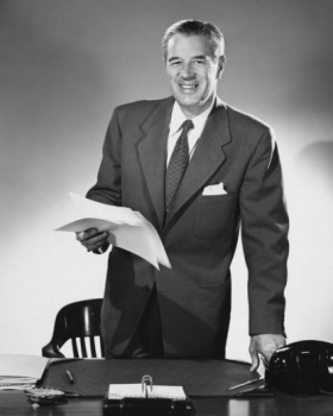 Businessman standing at a desk and holding documents in an office Canvas Art - (24 x 36)