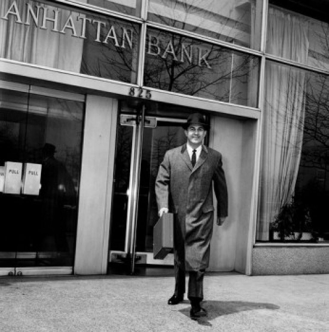 Businessman walking out of bank carrying briefcase Canvas Art - (18 x 24)