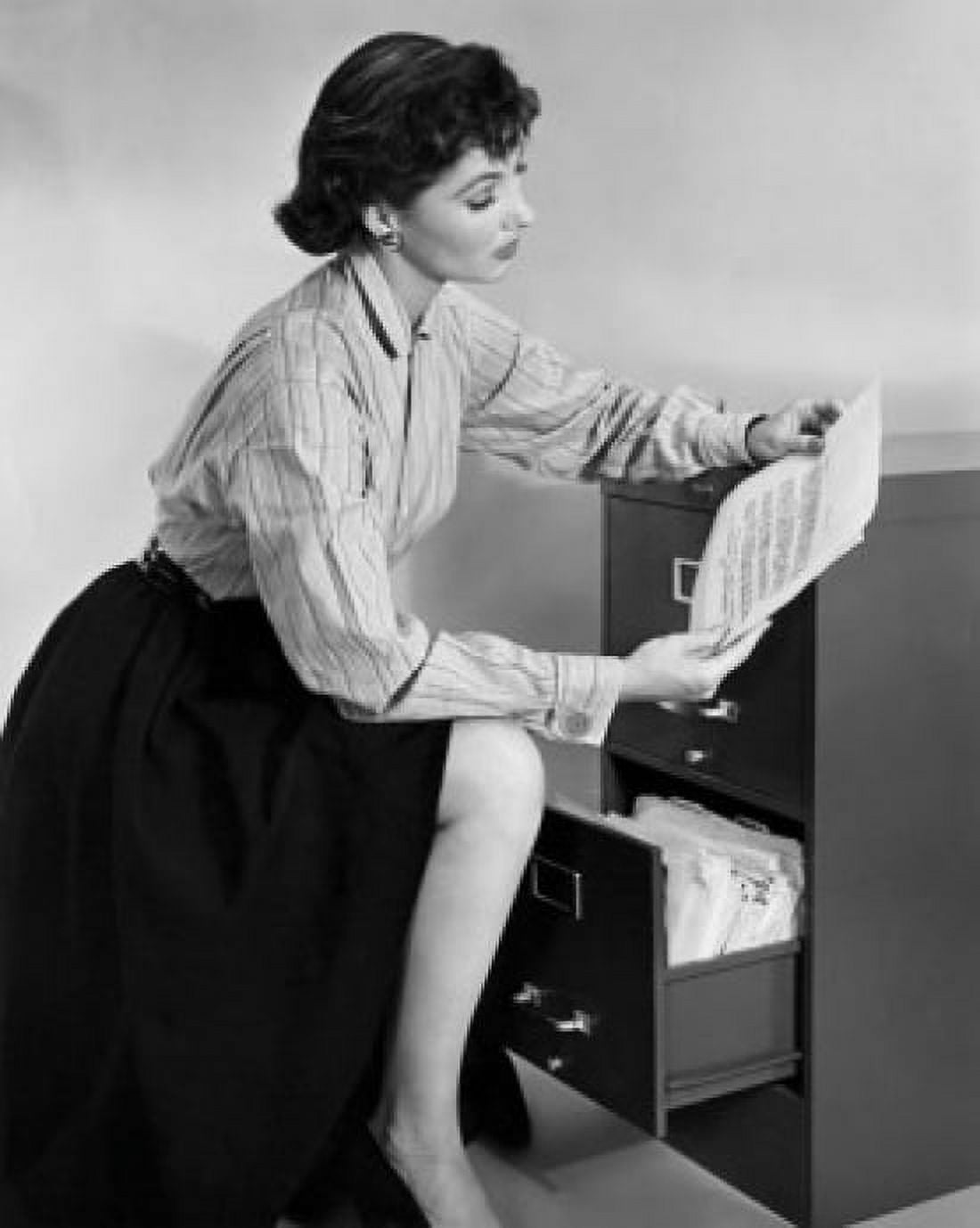 Businesswoman reading a document beside a filing cabinet Canvas Art -  (24 x 36)