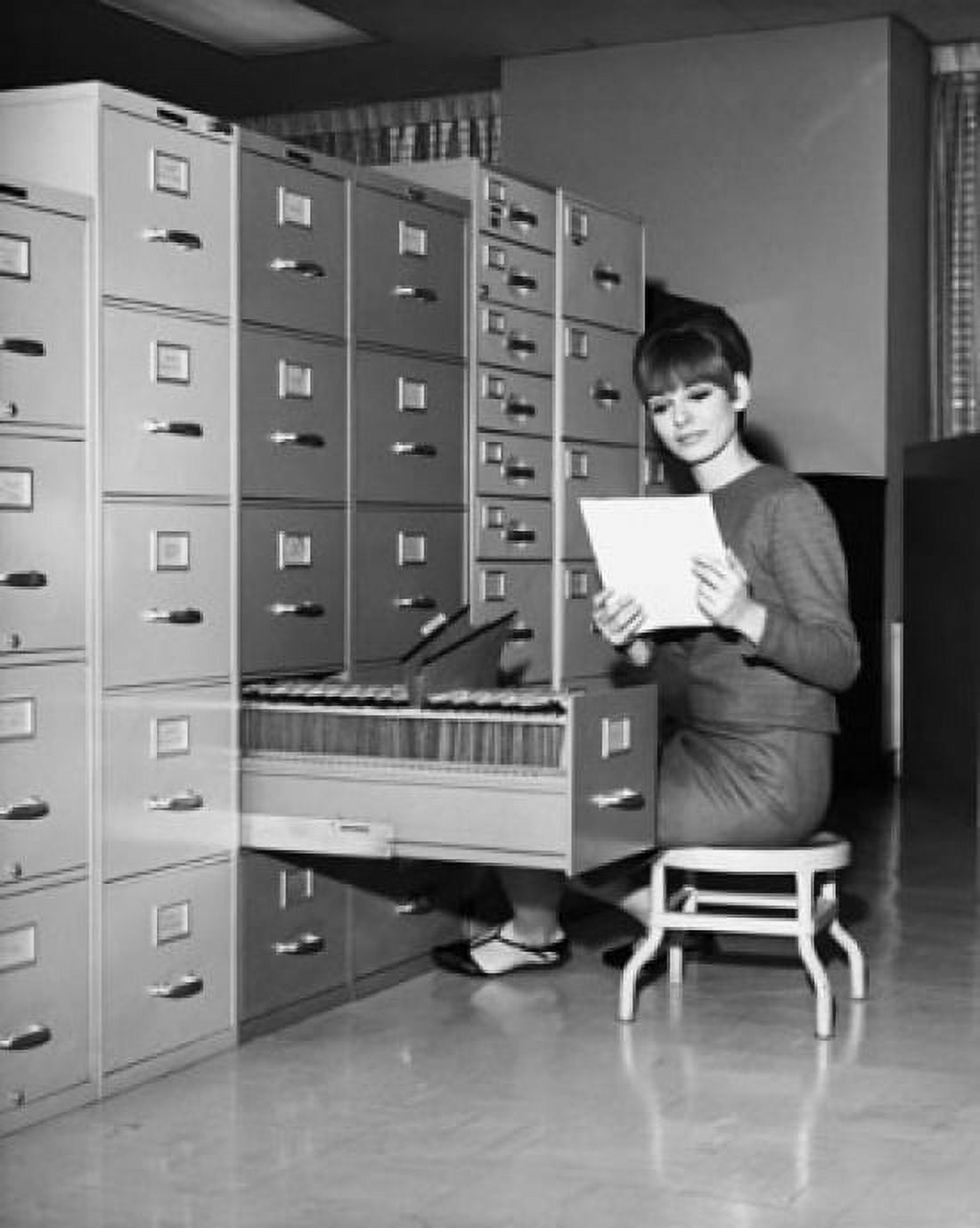 Businesswoman reading a document beside a filing cabinet Canvas Art - (24 x 36)
