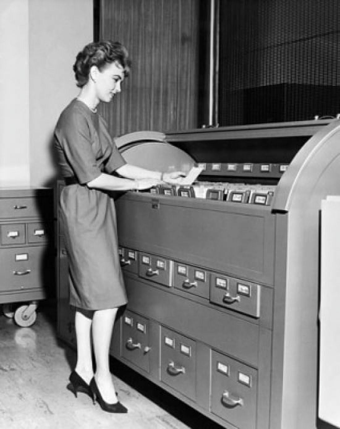 Businesswoman reading a document beside a filing cabinet Canvas Art - (24 x 36)