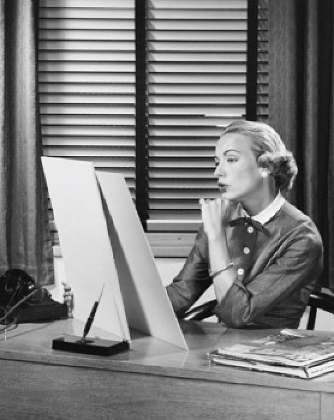 Businesswoman sitting at a desk and looking at a sketch pad in an office Canvas Art - (18 x 24)