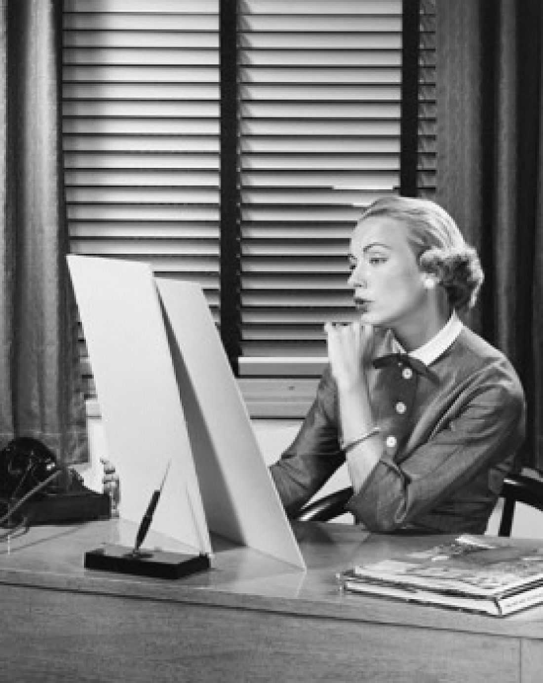 Businesswoman sitting at a desk and looking at a sketch pad in an office Canvas Art - (24 x 36)
