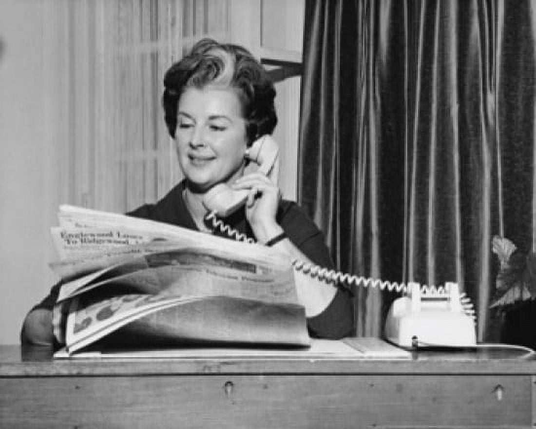 Businesswoman talking on the telephone and holding a newspaper in an office Canvas Art - (24 x 36)