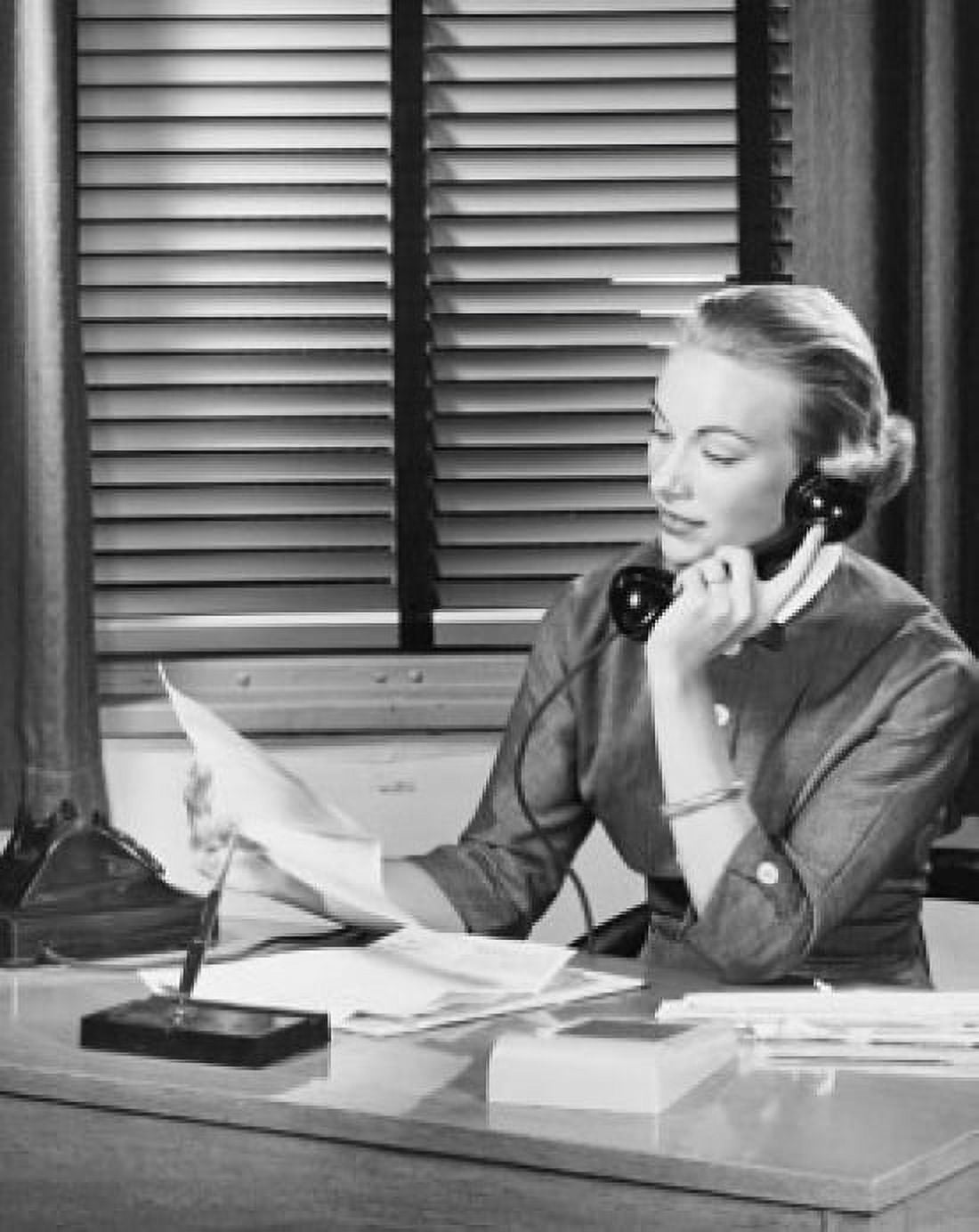 Businesswoman talking on the telephone and reading a document in an office Canvas Art - (24 x 36)