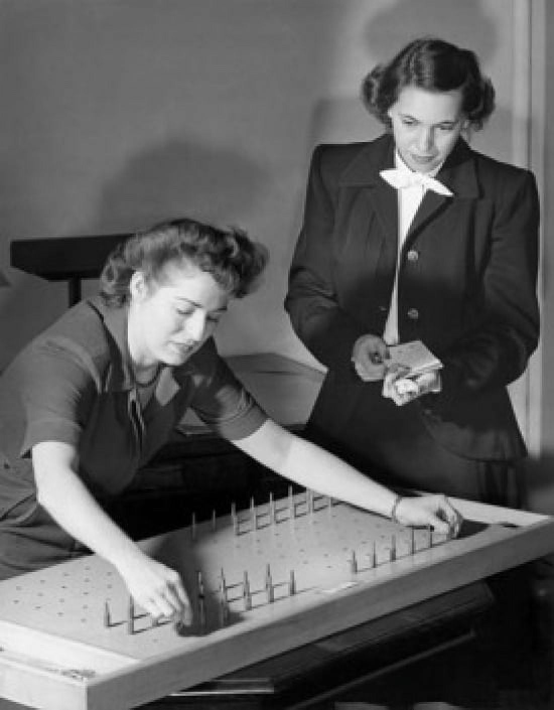 Businesswoman undergoing a manual dexterity test with another businesswoman standing beside her Canvas Art - (18 x 24)
