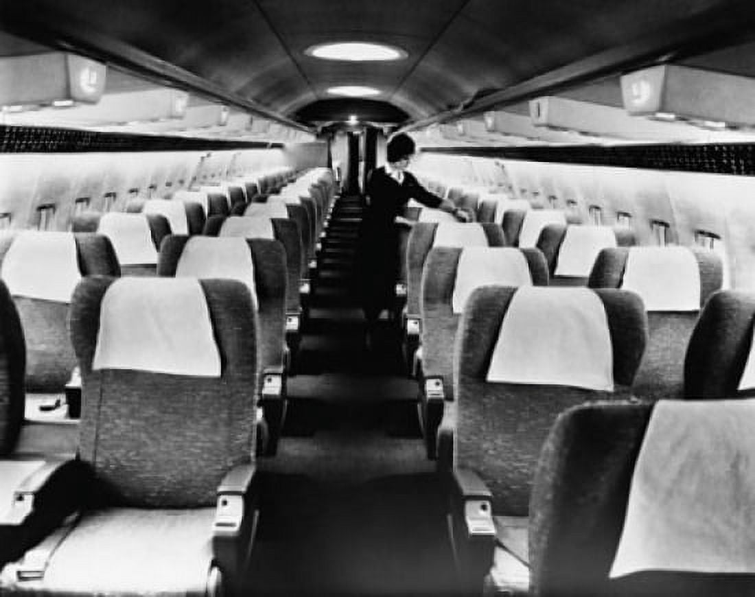 Cabin crew adjusting seats in an airplane Canvas Art - (18 x 24)