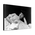 thumbnail image 1 of Canvas Print: Young Woman, Wearing Negligee, Lying In Bed, Holding Book, circa, 1 of 3
