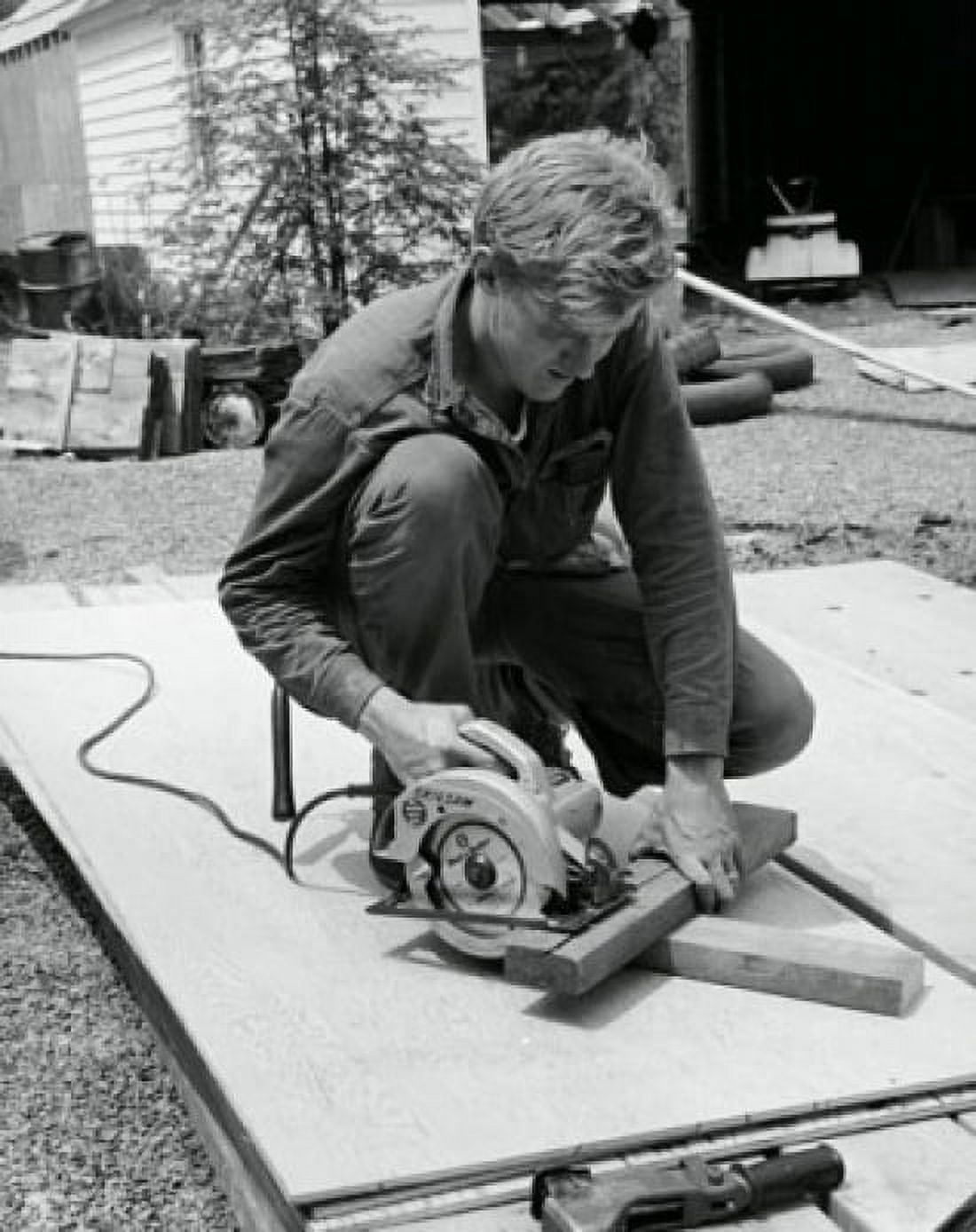 Carpenter sawing a wooden plank using an electric saw Canvas Art - (24 x 36)