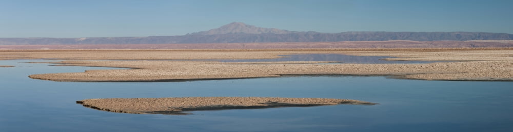 Chaxa Lake with mountain range in the background Los Flamencos National Reserve San Pedro de Atacama Antofagasta Region Chile Canvas Art - Panoramic Images (35 x 9)