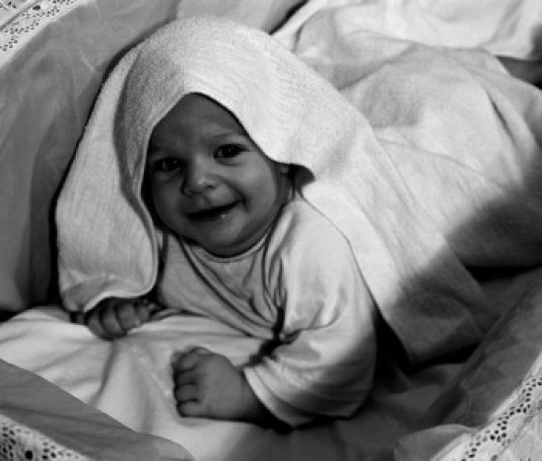 Child smiling and looking at camera covered with blanket Canvas Art - (24 x 36)