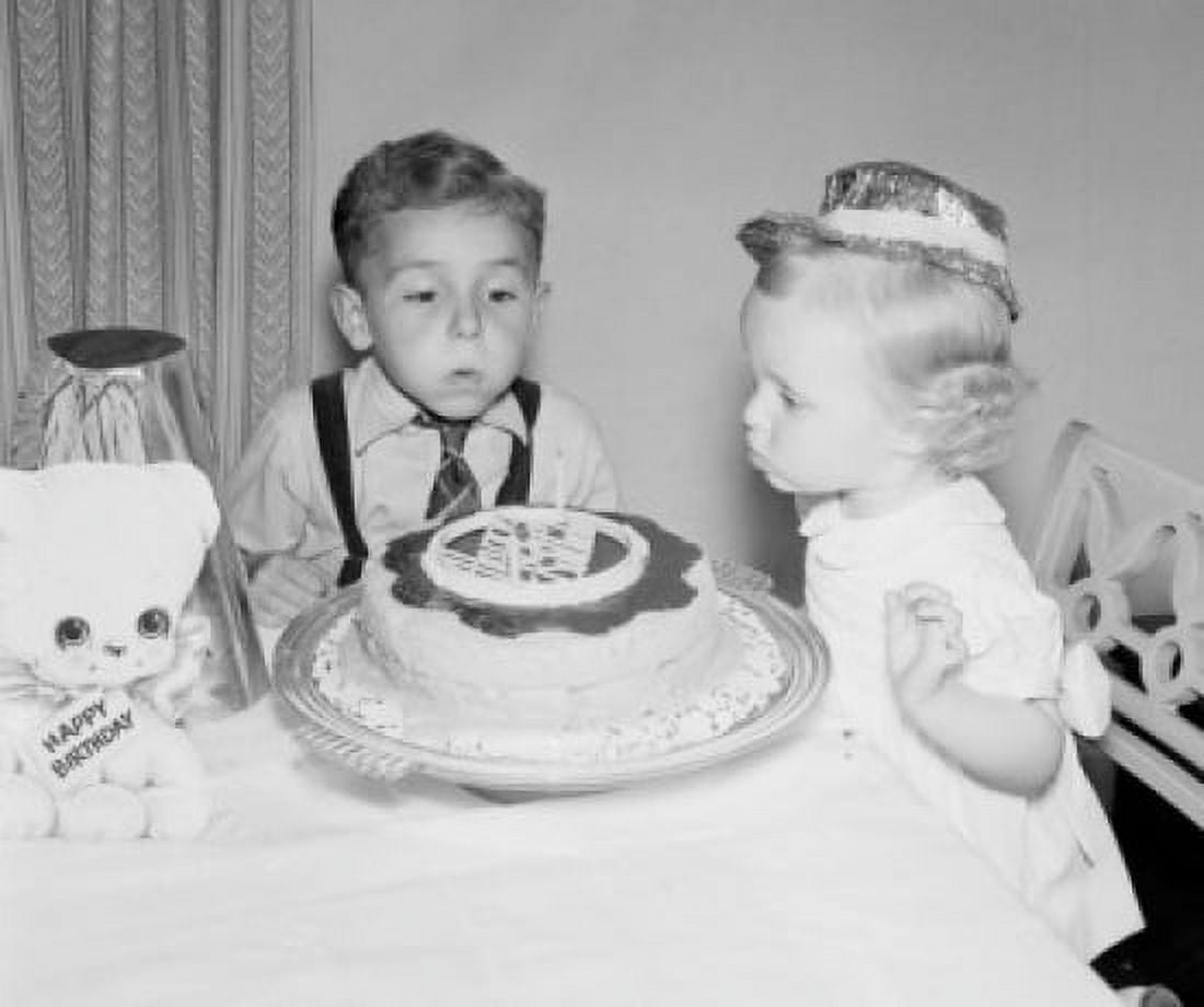 Children blowing candles on birthday cake Canvas Art - (18 x 24)