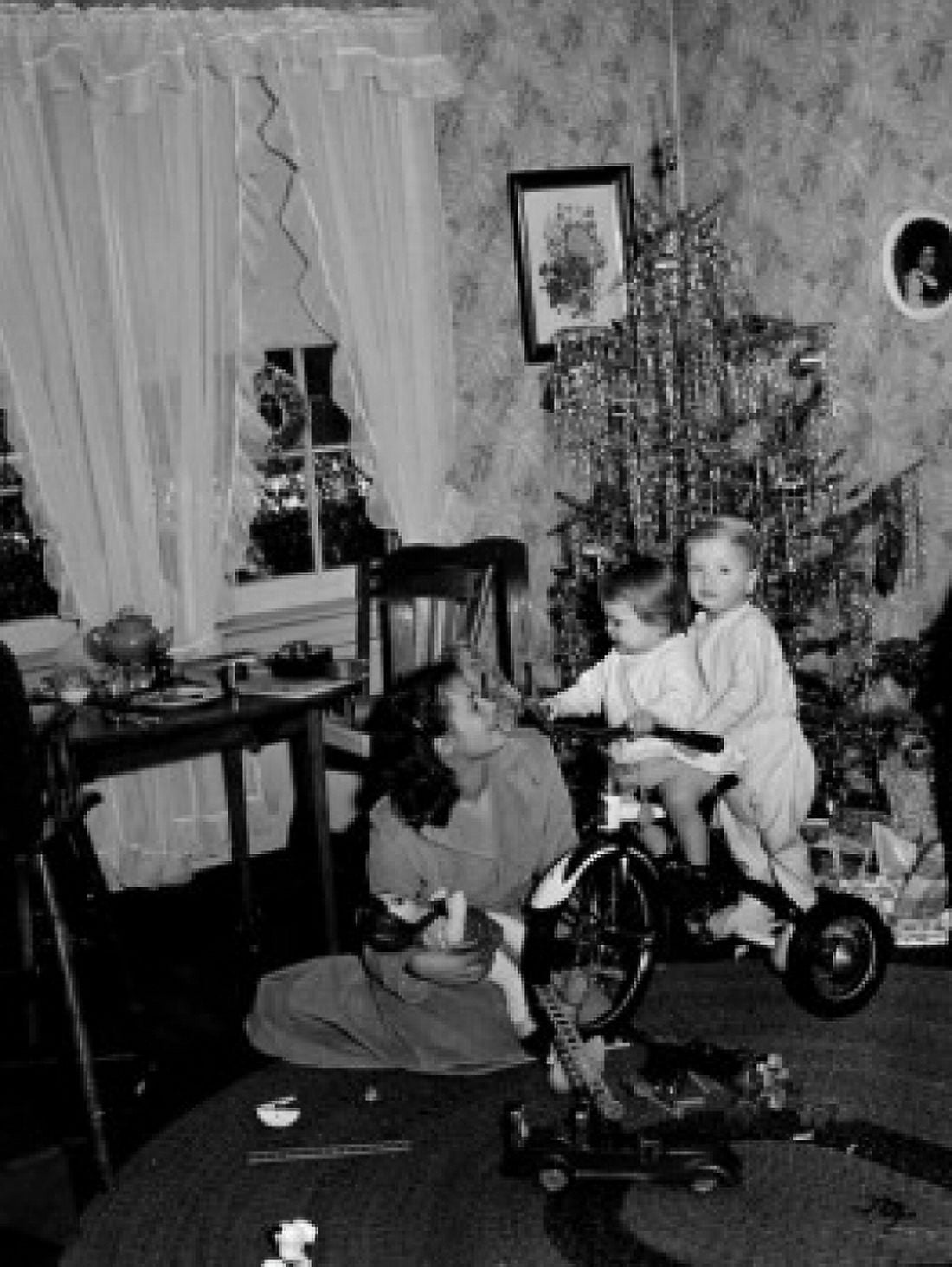 Children on tricycle by Christmas tree mother looking Canvas Art - (18 x 24)