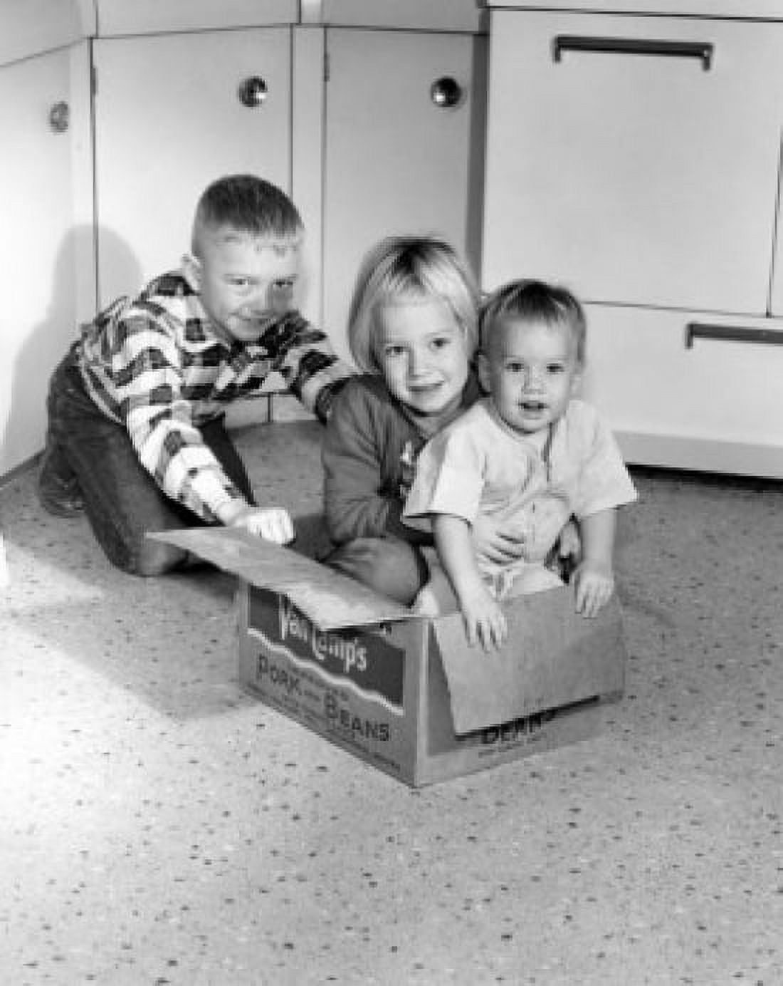 Children playing with cardboard box in kitchen Canvas Art - (18 x 24)