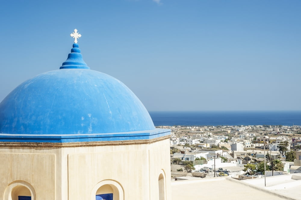 Church with a blue dome roof and view of the Aegean sea Megalochori Santorini Greece Canvas Art - Dosfotos  Design Pics (19 x 12)