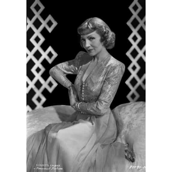 Claudette Colbert sitting on Bed, wearing Floral Dress Photo Print (8 x 10)