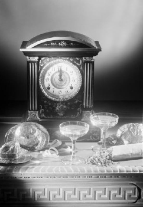 Clock showing 12 oclock with champagne flutes and part hats in the foreground Canvas Art - (18 x 24)