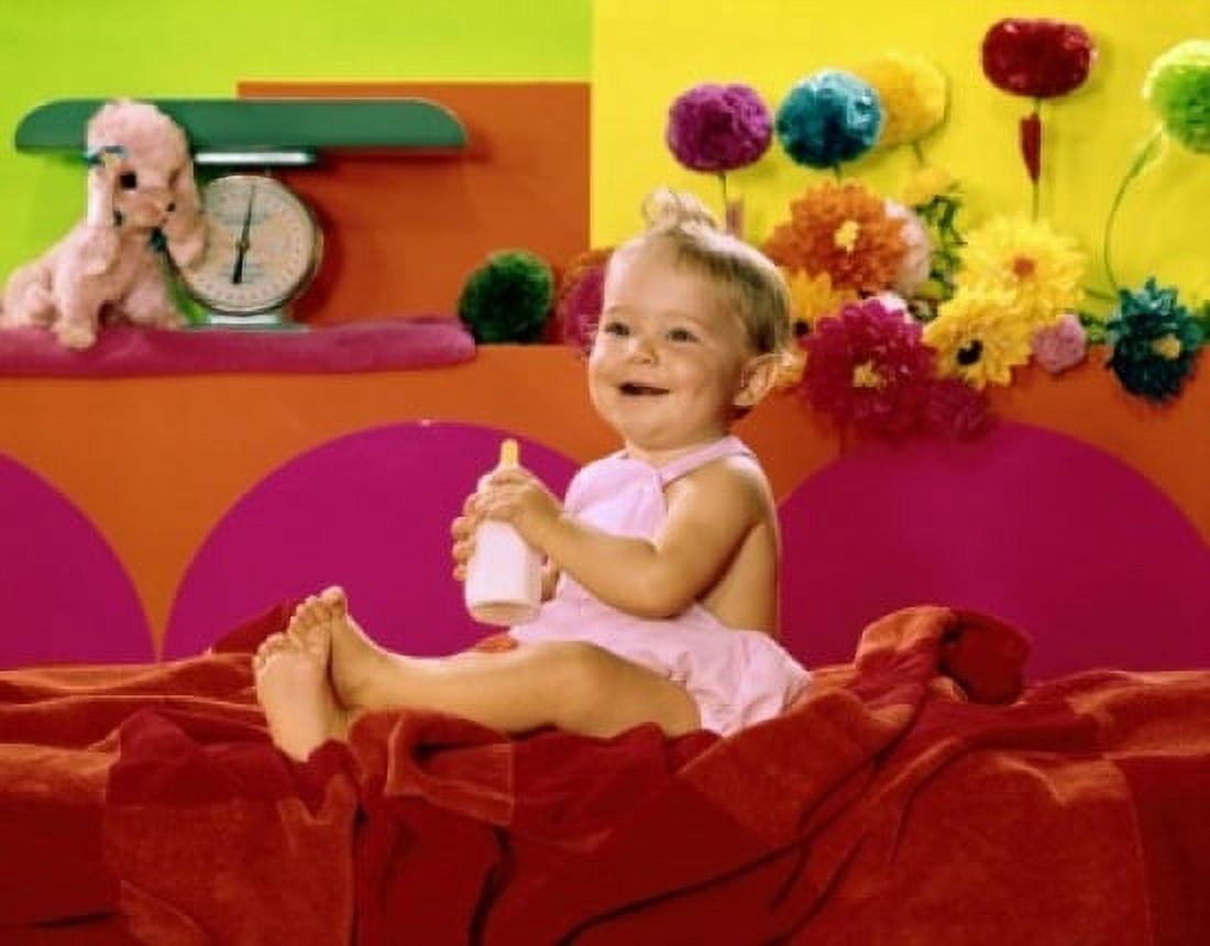 Close-up of a baby girl holding a baby bottle and smiling Canvas Art - (24 x 36)