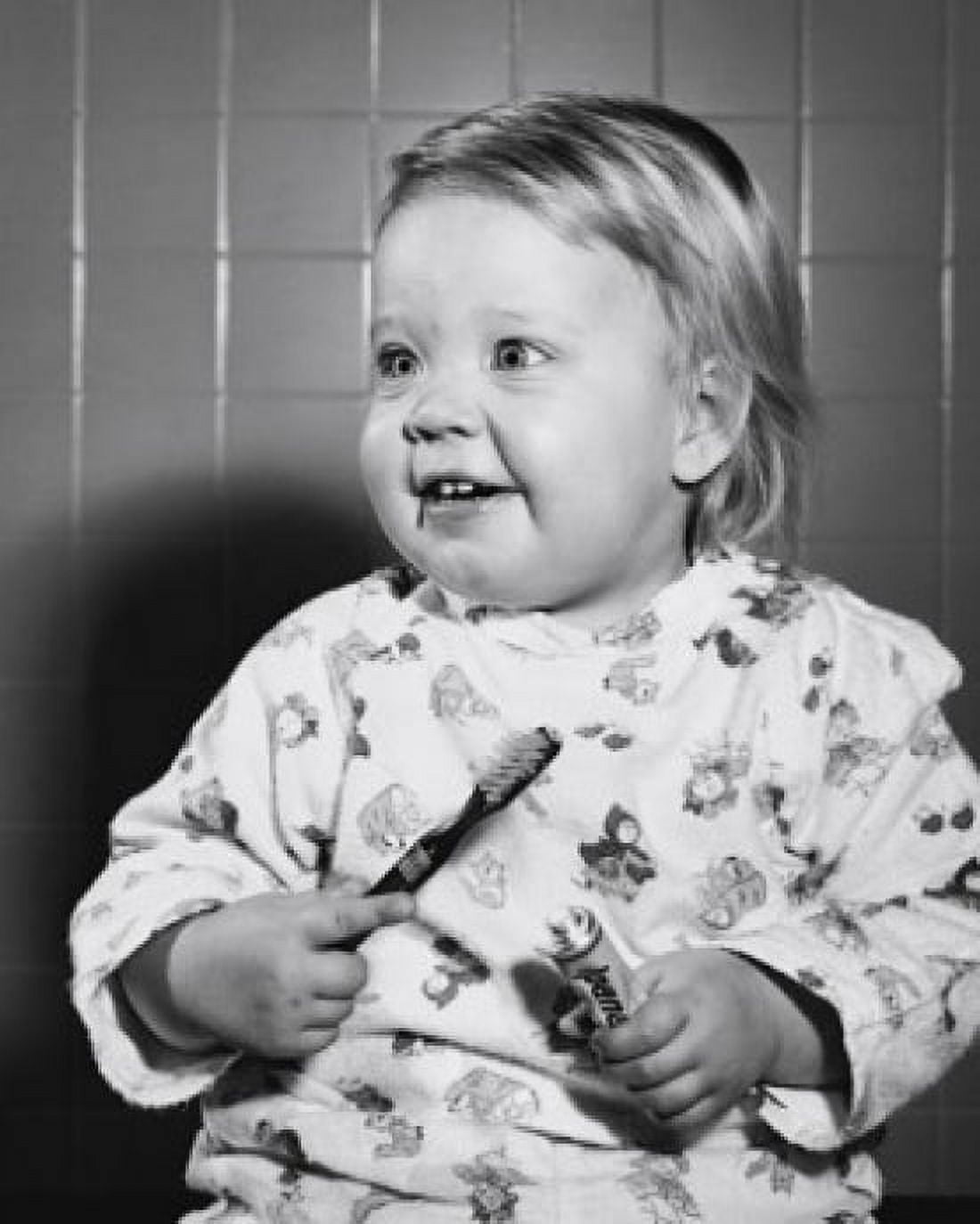 Close-up of a baby holding a toothbrush and toothpaste Canvas Art - (18 x 24)