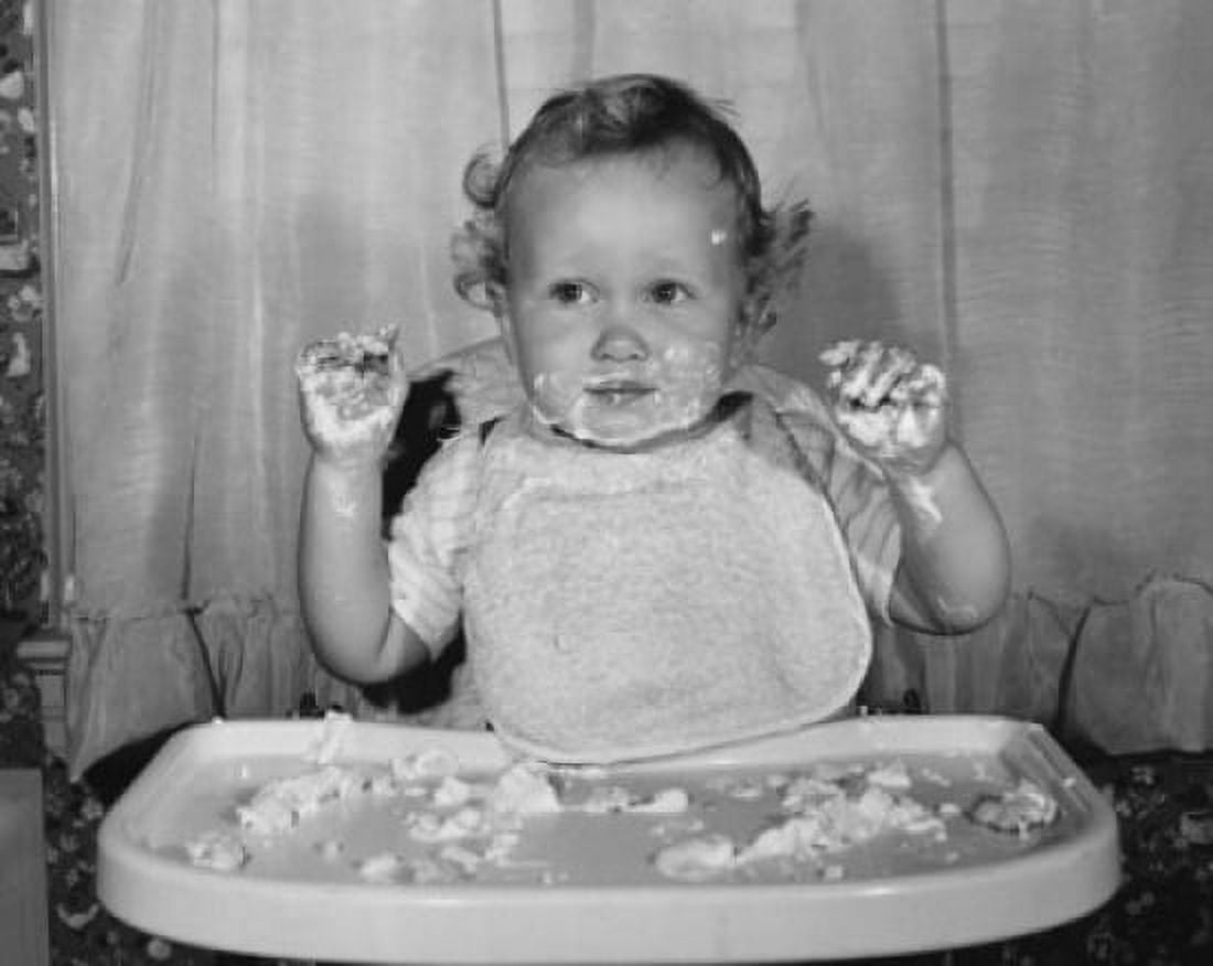 Close-up of a baby sitting in a high chair with food on his face and hands Canvas Art - (18 x 24)