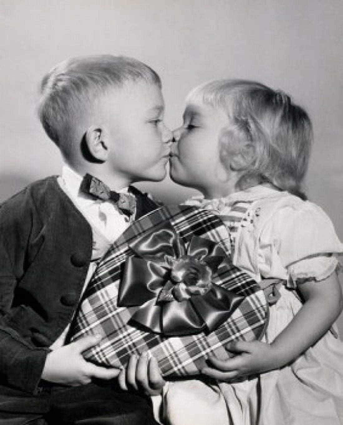Close-up of a boy and a girl holding a Valentine gift and kissing each other Canvas Art - (18 x 24)