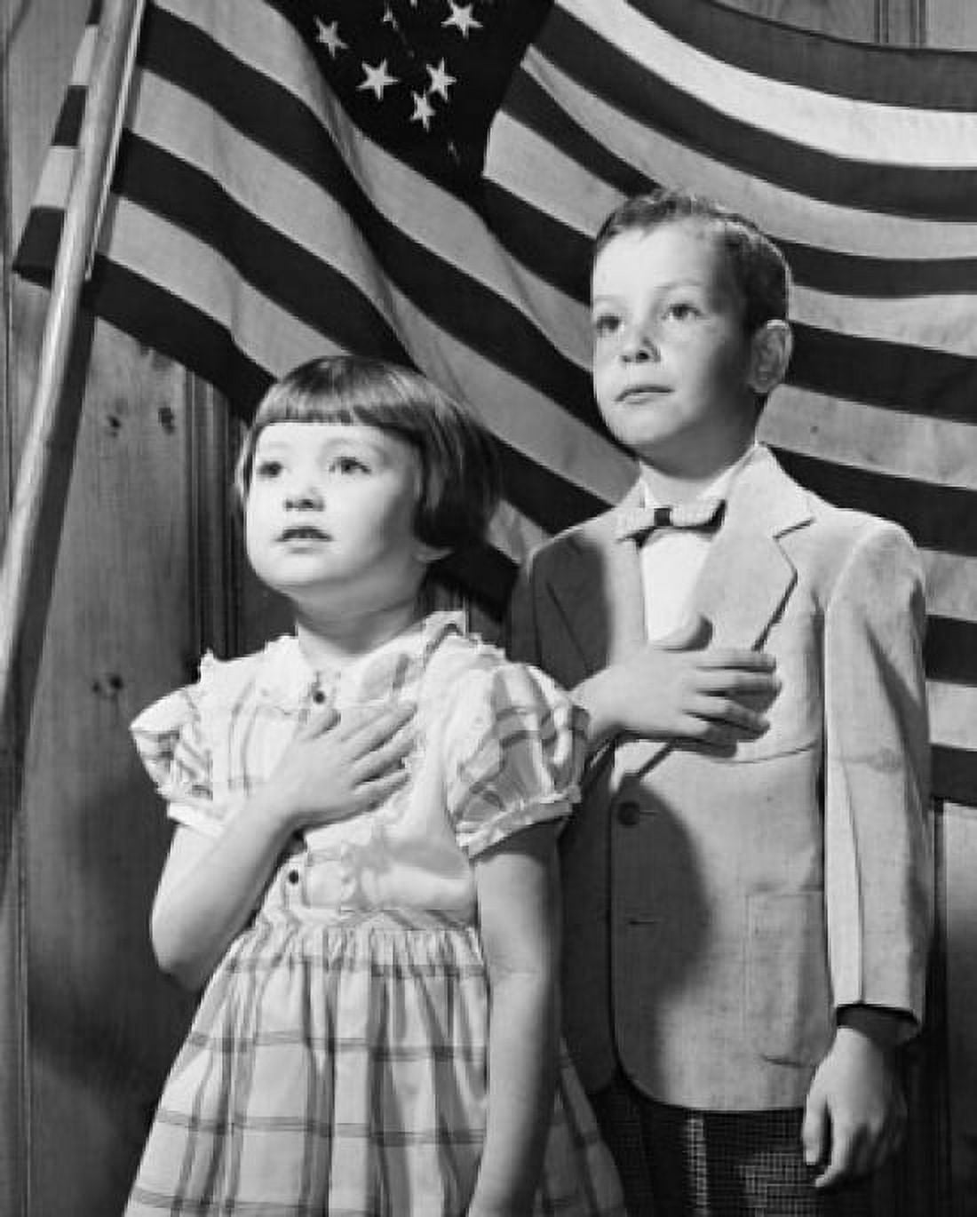 Close-up of a boy and a girl taking a Pledge of Allegiance in front of an American flag Canvas Art - (24 x 36)