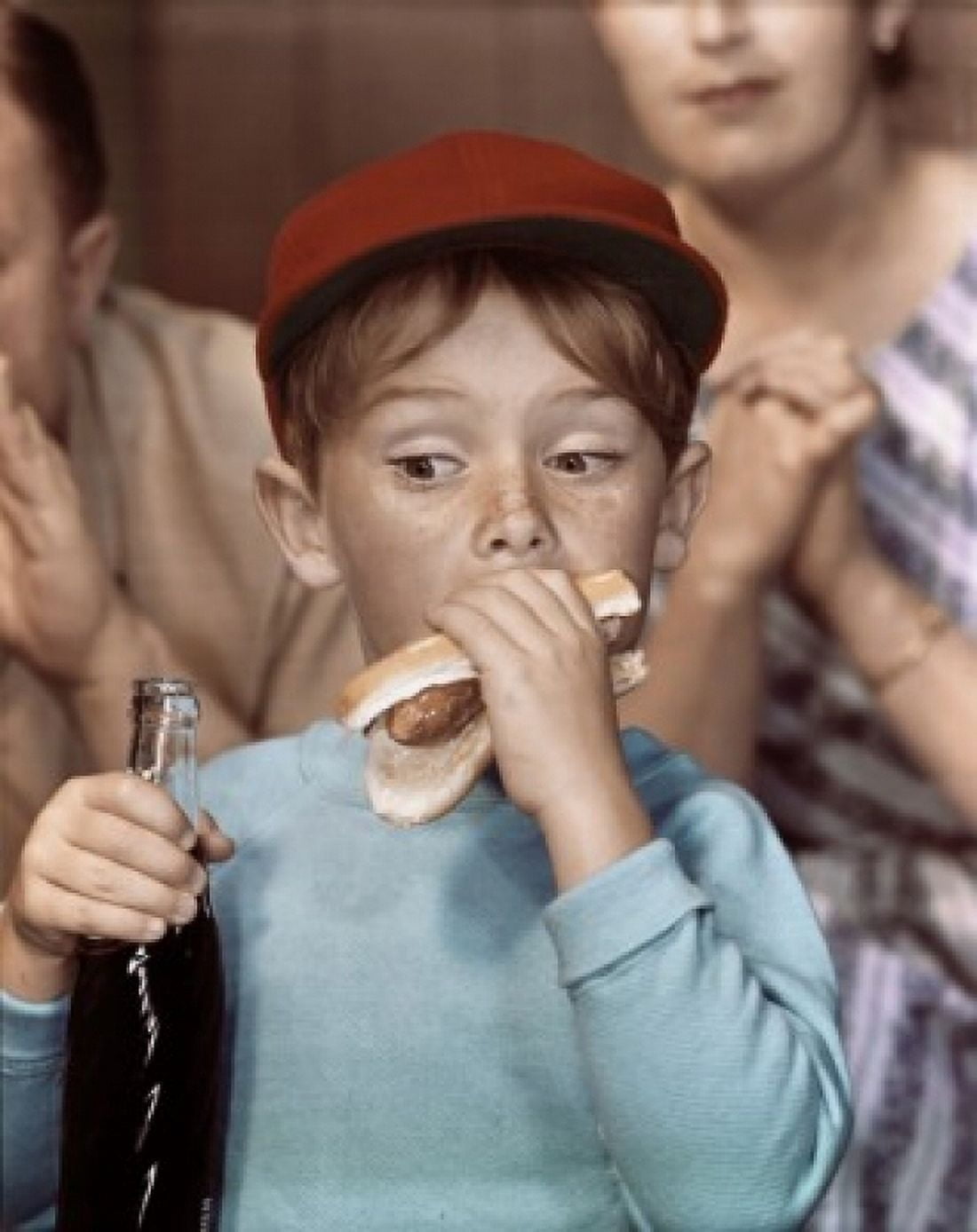 Close-up of a boy eating a hot dog and holding a bottle of soda Canvas Art - (24 x 36)