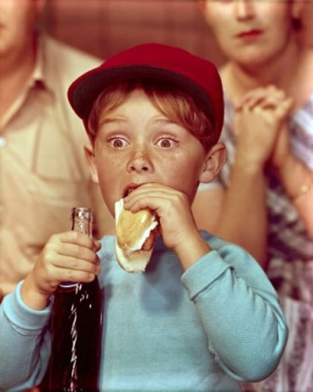 Close-up of a boy eating a hot dog and holding a bottle of soda Canvas Art - (24 x 36)