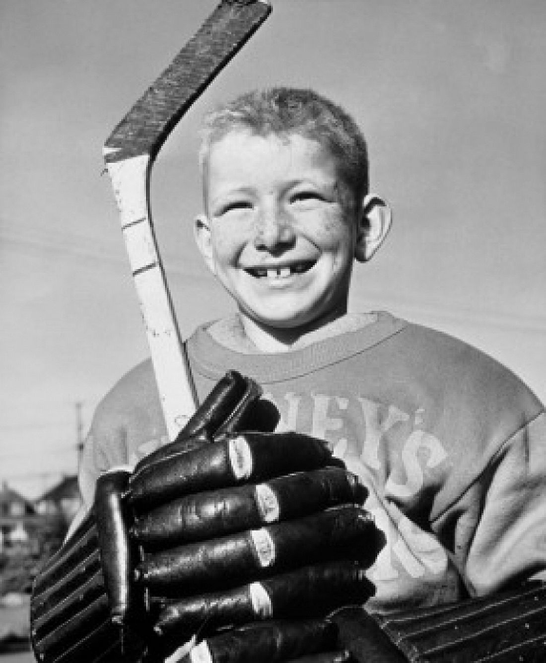 Closeup of a boy holding a hockey stick smiling Poster Print (24 x 36