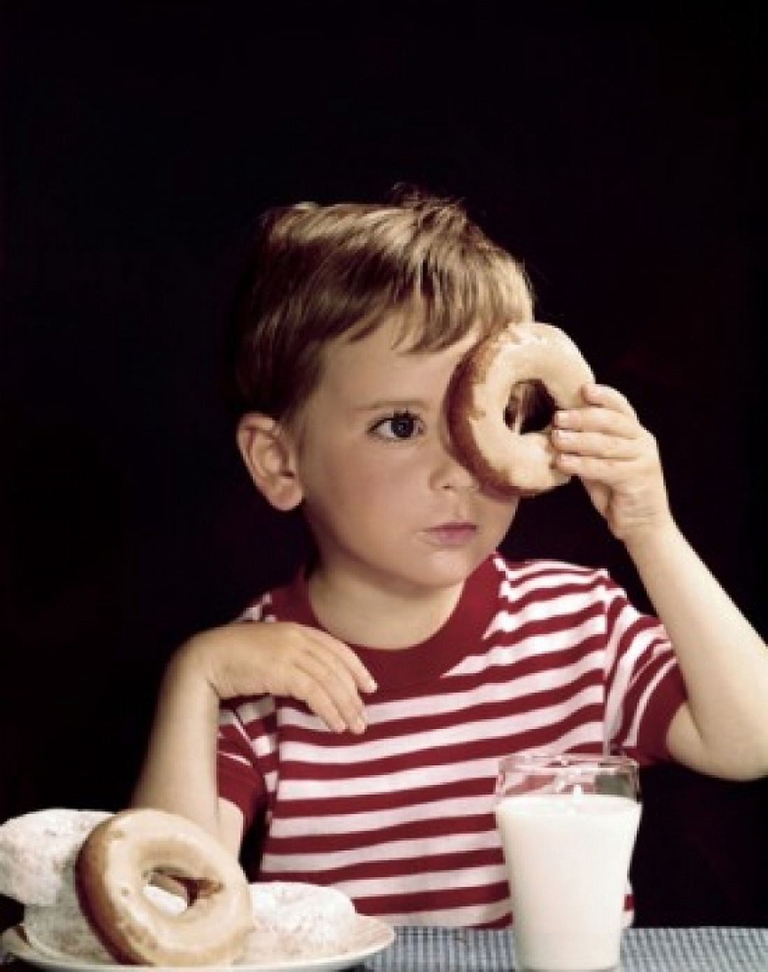 Close-up of a boy looking through a donut Canvas Art - (24 x 36)
