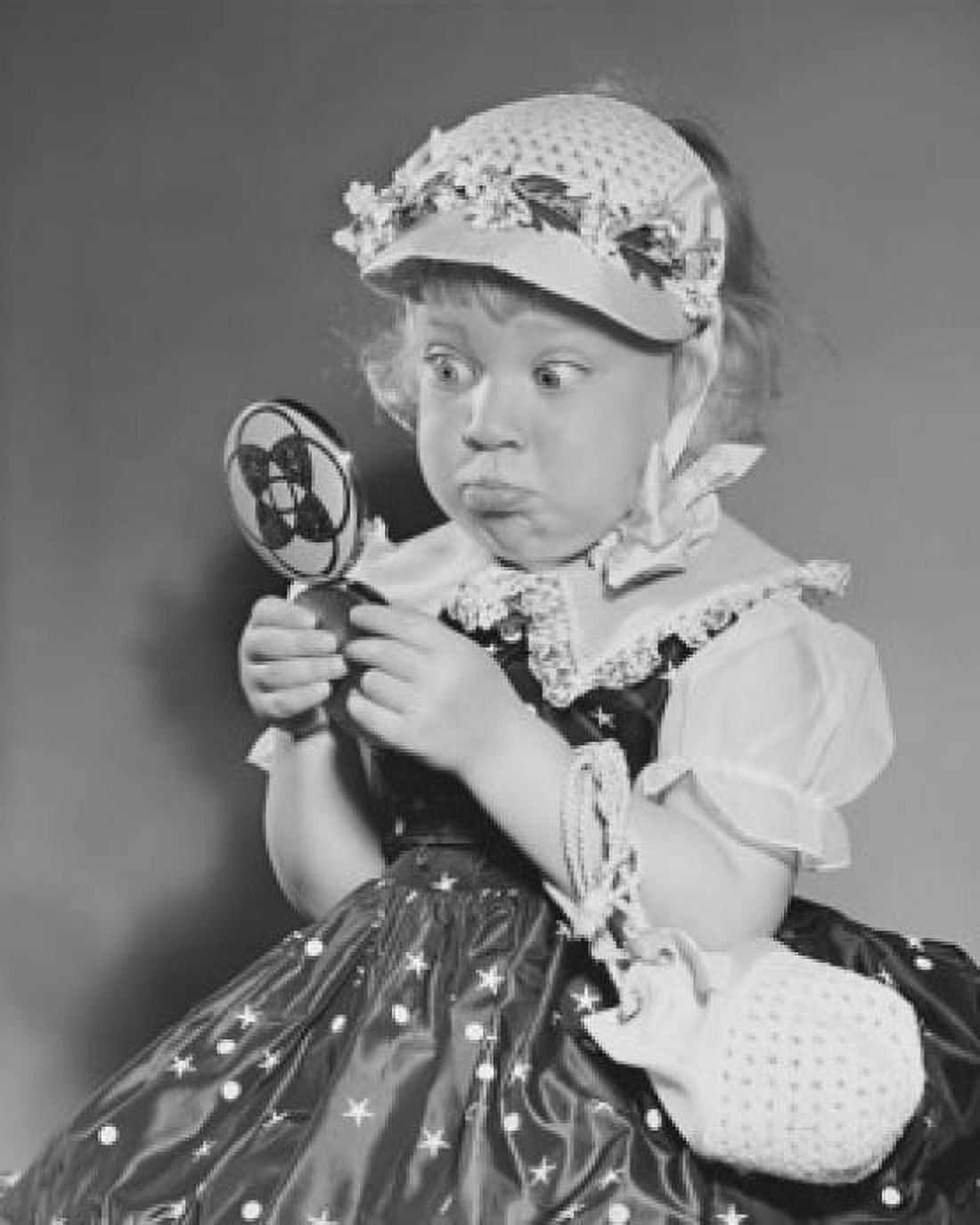 Close-up of a girl holding a hand mirror and making a face Canvas Art - (18 x 24)