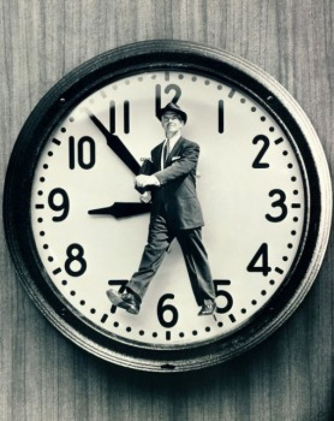 Close-up of a man walking in front of a clock Canvas Art - (24 x 36)