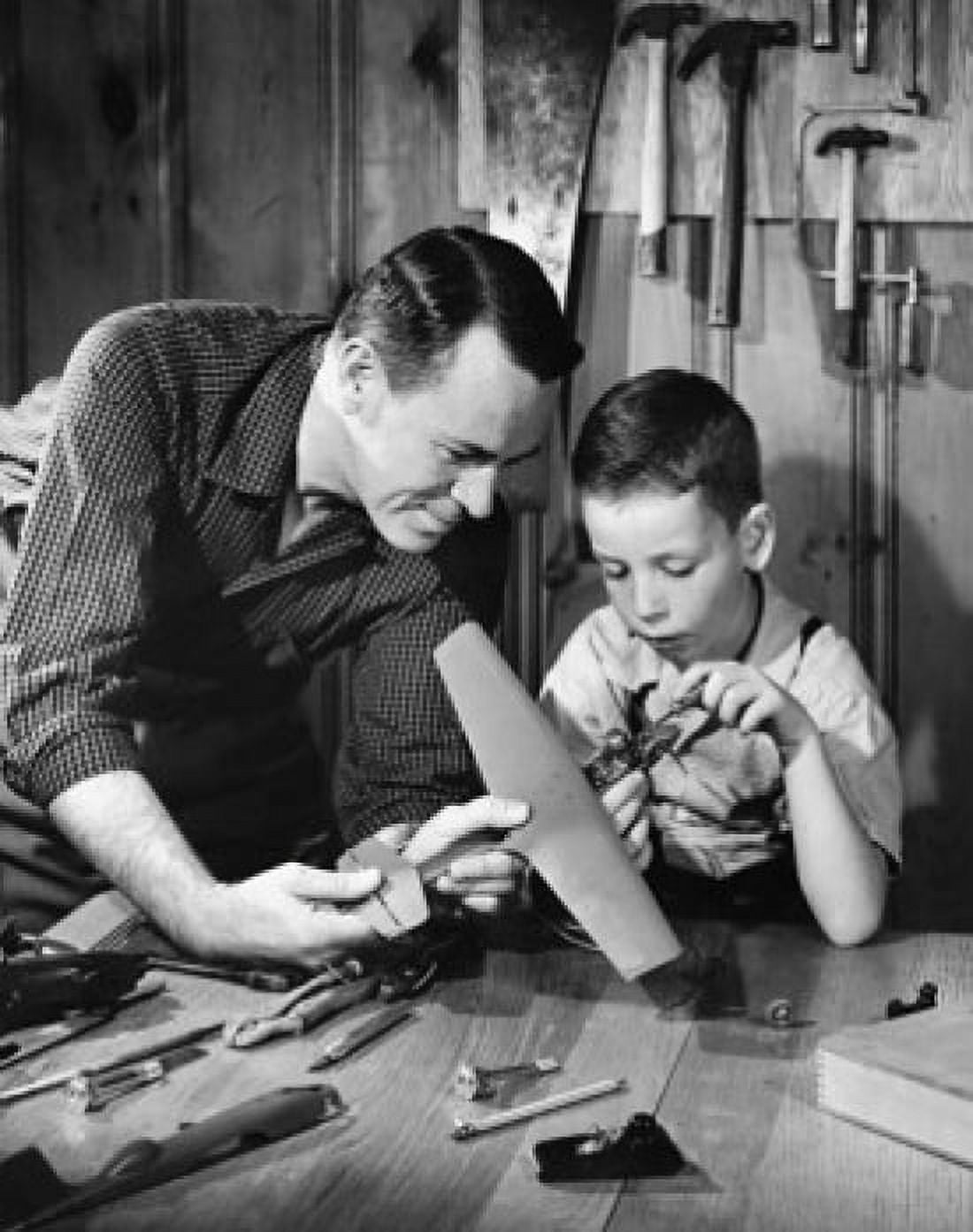 Close-up of a mature man with his son making a model of an airplane Canvas Art - (18 x 24)