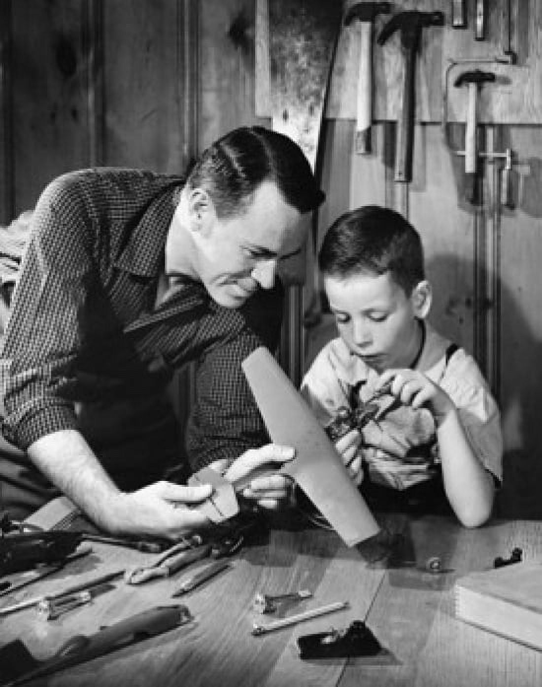 Close-up of a mature man with his son making a model of an airplane Canvas Art - (24 x 36)