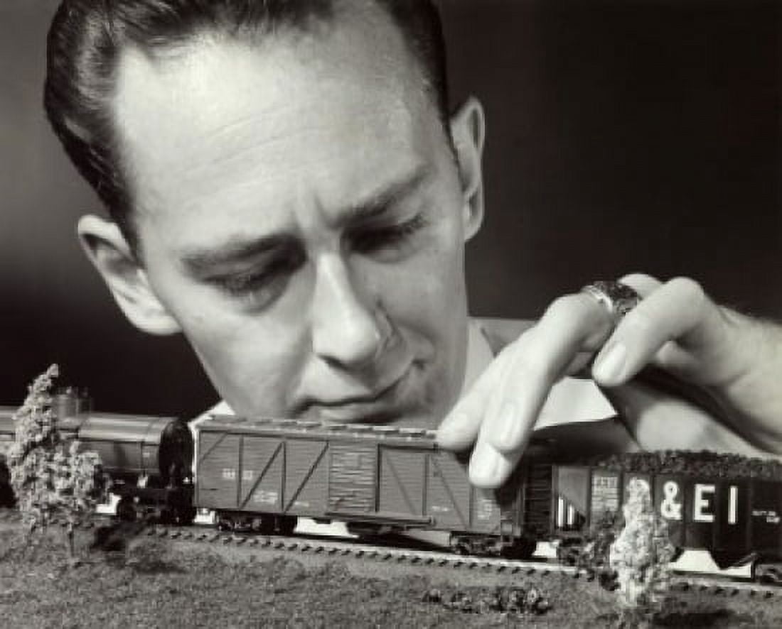 Close-up of a mid adult man holding a model of a toy train Canvas Art - (18 x 24)