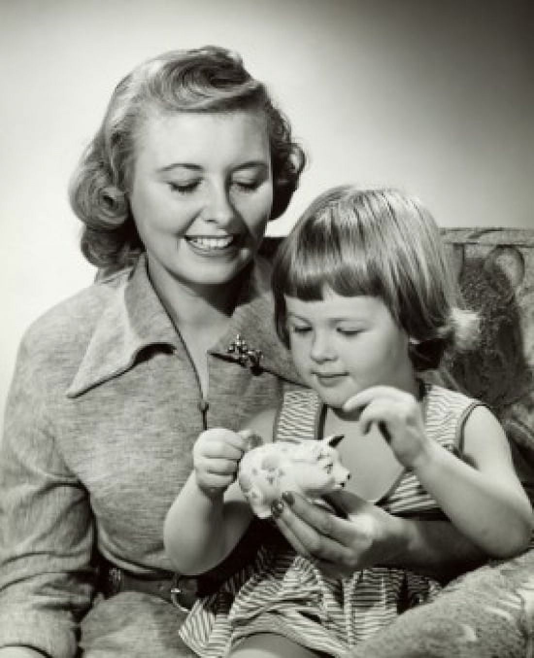 Close-up of a mother watching her daughter putting coin into a piggy bank Canvas Art - (24 x 36)